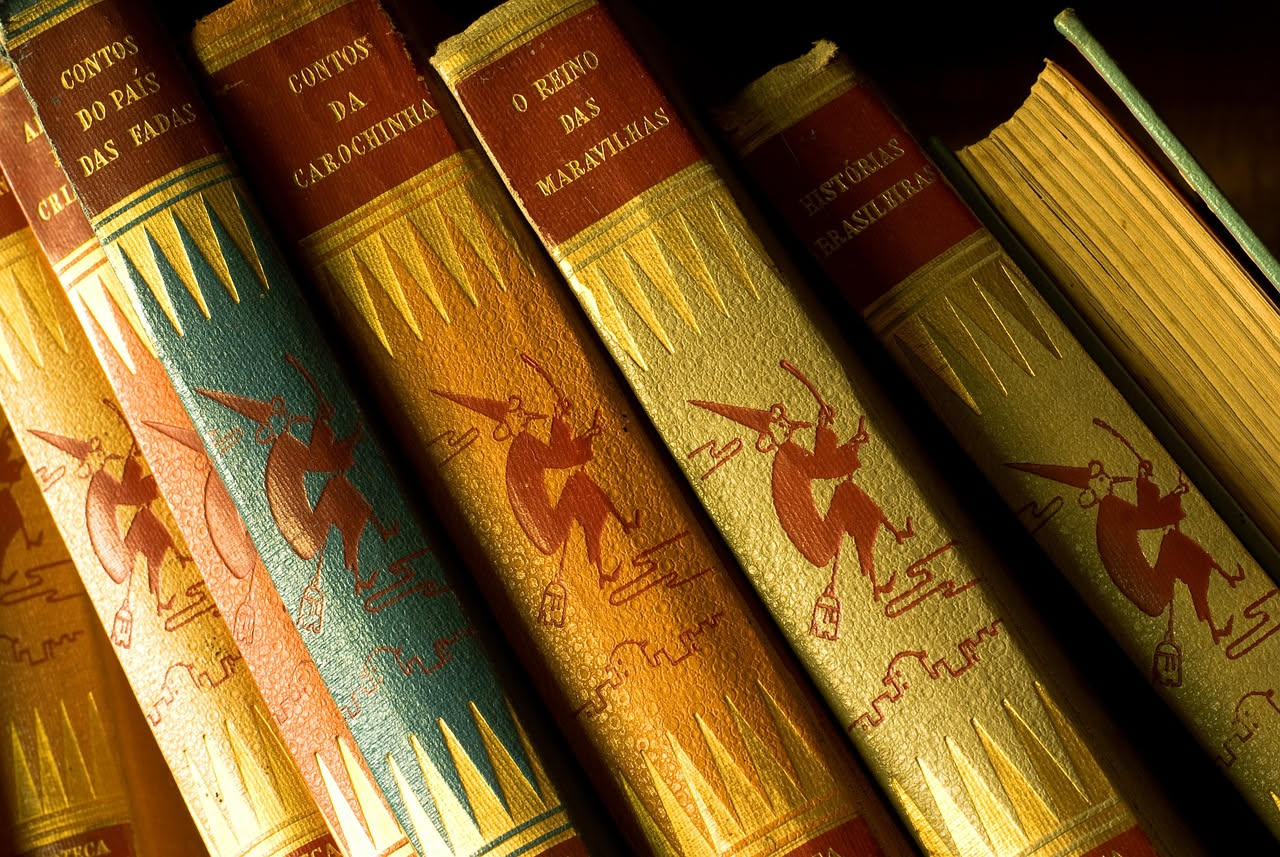 Copia antica di Orgoglio e pregiudizio con copertina in pelle logora, aperta su una pagina ingiallita, accanto a una rosa rossa su tavolo di legno scuro