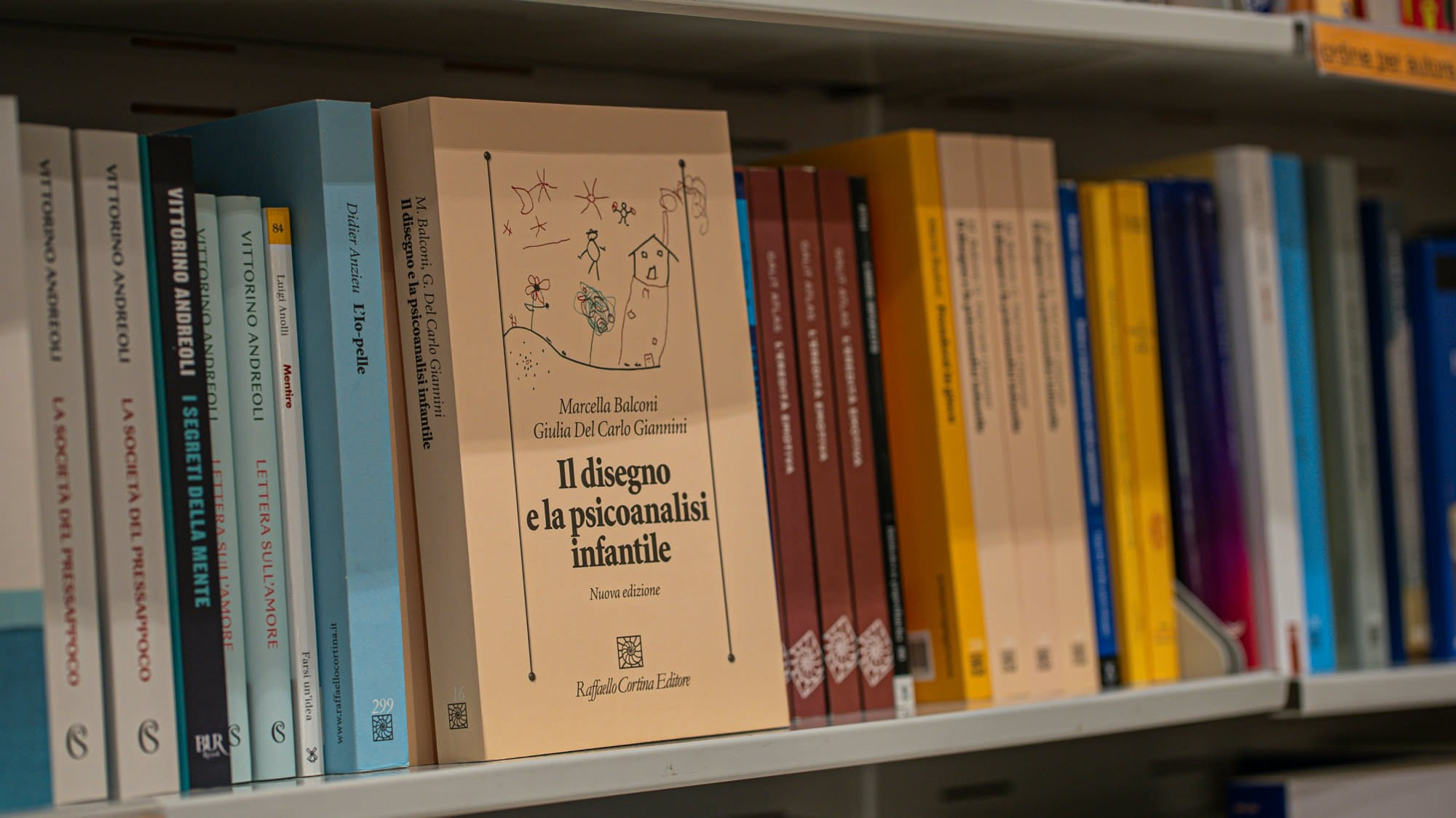 Scrivania di legno con penna, occhiali e libri aperti accanto a una finestra