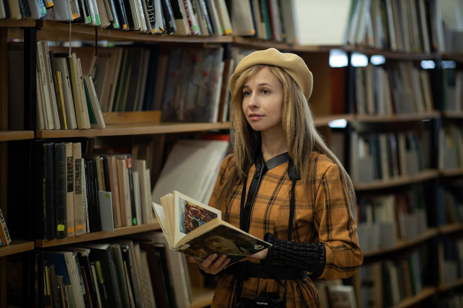 Scaffali di una grande biblioteca con volumi rilegati in penombra