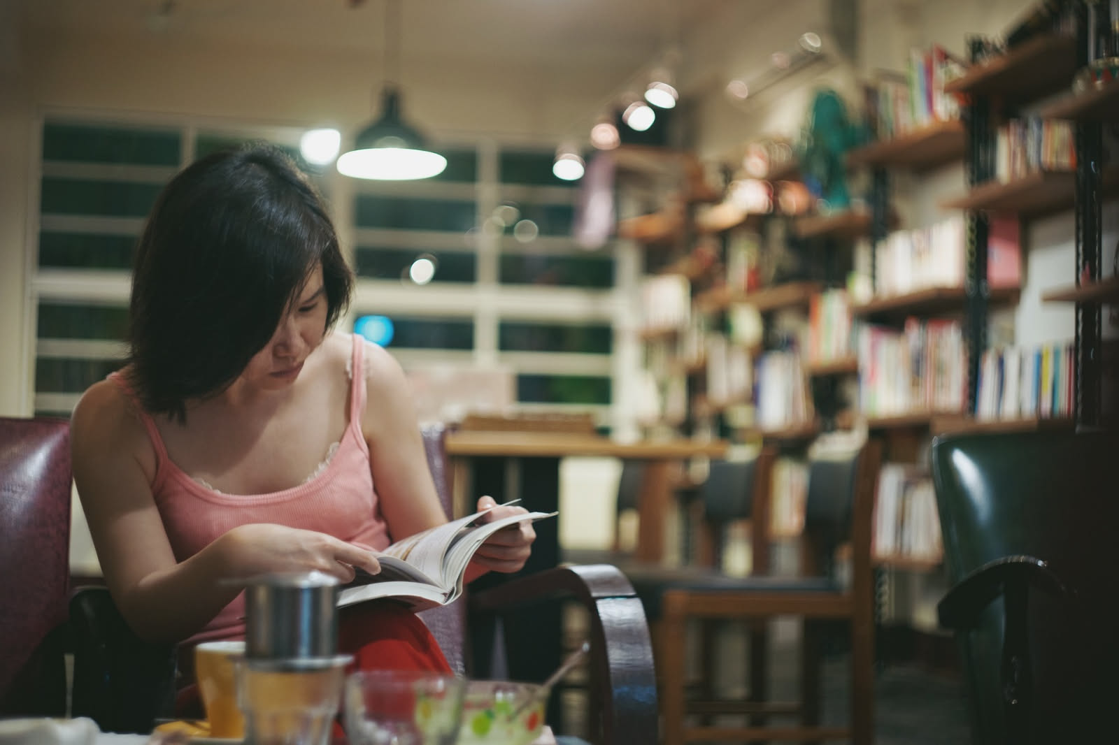 Lettrice che restituisce un romanzo al banco di una biblioteca pubblica